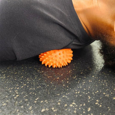 Balle de massage epaule appuyé sur ballon orange