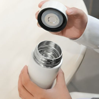 Gourde isotherme tête ouverte dans mains gauche droite