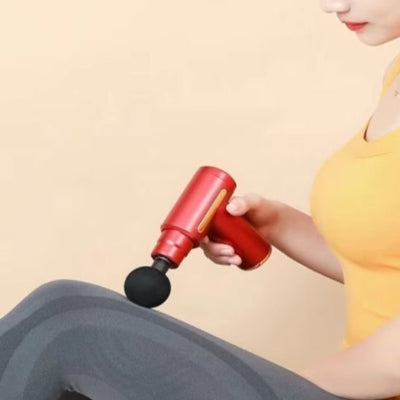 Pistolet de massage rouge masse cuisse femme assise