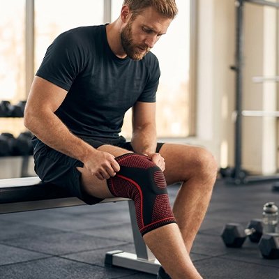 Genouillere pour le sport​ profil homme assis 