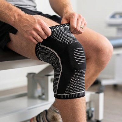 Genouillere pour le sport​ profil assis mains genouillère